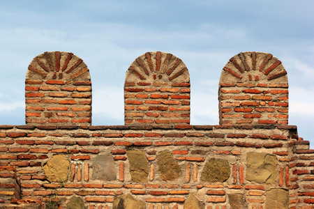 Old brick stone fortress wall with battlementsのeditorial素材
