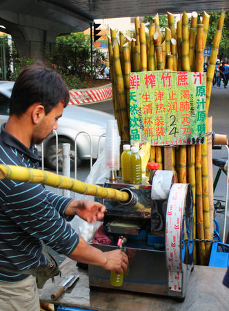 GUANGZHOU, CHINA, MARCH 5, 2012: Street vendor squeezes fresh bamboo and sugarcane juice in Guangzhou. These healthy and refreshing drinks are very popular in southern China.のeditorial素材