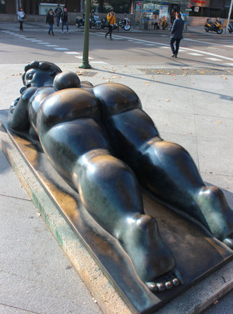 MADRID, SPAIN - DECEMBER 13, 2016: Sculpture of fat woman with a mirror (Mujer con espejo) lying down at Plaza de Colon, by Fernando Botero. Gift from the Colombian sculptor to the city of Madrid.のeditorial素材