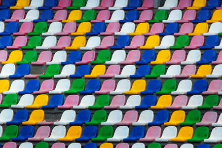 Rows of old plastic colorful seats at a stadiumの写真素材