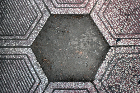 Missing tile in old dirty paved sidewalk