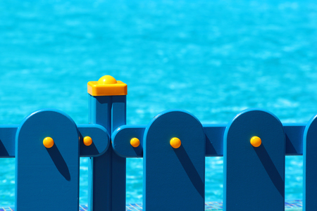 Blue fence at a pool with clear waterの写真素材