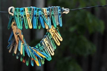 Old clothes pegs hanging on a ropeの写真素材
