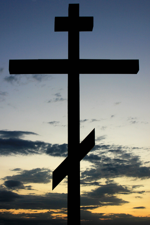 Silhouette of orthodox cross against sunset sky backgroundの写真素材