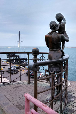 Odessa, Ukraine - December 16, 2017: Woman with son waving farewell to the father sailor on a pier. Statue of a sailor's wife by Alexander Tokarev installed at Odessa passenger sea port in 2002.のeditorial素材