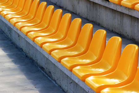 Rows of plastic yellow seats at a stadiumの写真素材
