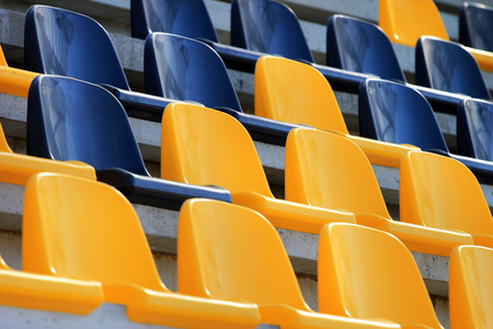 Rows of plastic black and yellow seats at a stadiumの写真素材