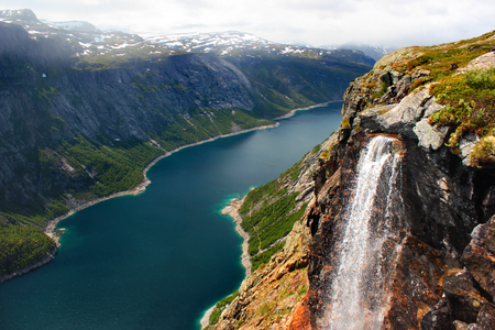 Lake Ringedalsvatnet, snow covered mountains and a waterfall on the way to Trolltunga, Norway. Beautiful scandinavian landscape.の写真素材
