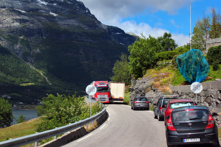 Ullensvang, Norway - June 22, 2018: Traffic jam on a narrow coastal road. Cars are waiting for the trucks to pass each other on a roadway along Hardanger fjord.のeditorial素材