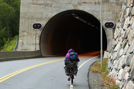 Bicycle tourist entering a tunnel, Norwayの写真素材