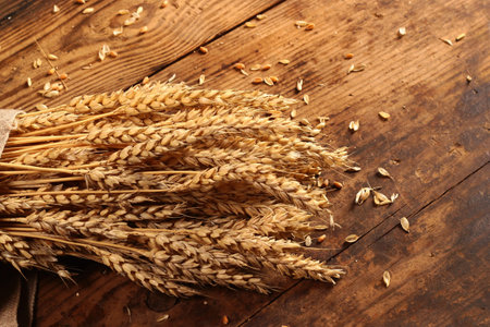 Ears of wheat and grain on a wooden background