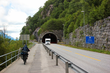 Tyssedal, Norway - June 22, 2018: A bicyclist riding on a coastal bike lane, detouring the tunnel at Hardanger fjord in Hordaland county, Southern Norway.のeditorial素材