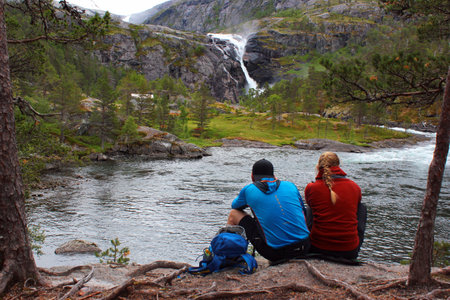 Husedalen, Norway - June 23, 2018: Tourists taking photos of Nykkjesoyfossen falls, the third in cascade of four waterfalls in Husedalen valley near Kinsarvik village.のeditorial素材