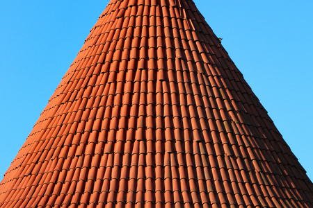 Red tiled conical roof of a towerの写真素材