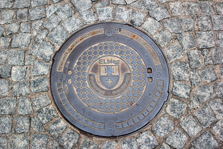Elblag, Poland - May 9, 2019: A manhole cover of Elblag waterworks in the renovated historical Old Town.のeditorial素材