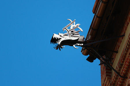 Gorowo Ilaweckie, Poland - May 7, 2019: Rain gutter decorated with dragon gargoyle head on the Sacred Heart of Jesus church.のeditorial素材