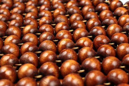 Wooden beads rug. Hand made car seat. Natural varnished wood background.の写真素材