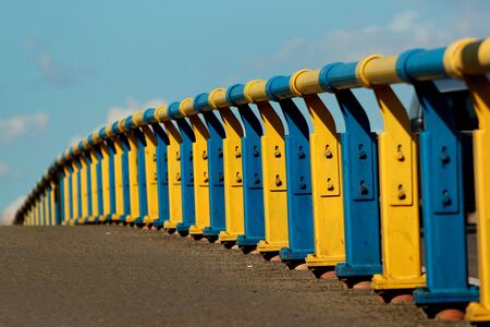 Metal railing on a bridge in Kyiv, Ukraine. Painted in yellow and blue colors of Ukrainian flag.の写真素材