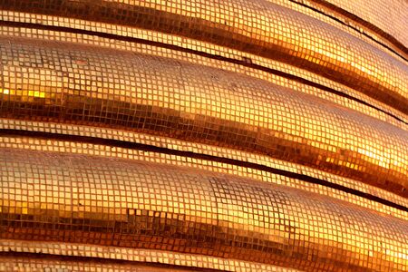 Golden tiles of a Buddhist stupa, Thailand. Abstract Southeast Asian background.の写真素材