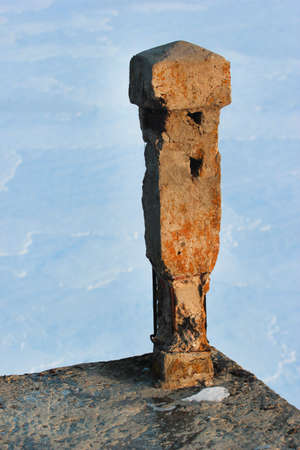 Detail of an old abandoned bridge with broken railing over a frozen riverの写真素材