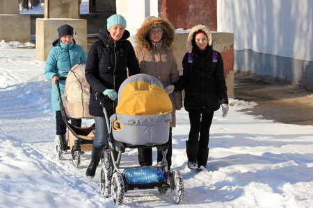 Kharkiv, Ukraine - January 21, 2018: Happy mothers with baby prams walking and enjoing a sunny winter day.のeditorial素材