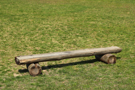 Wooden logs bench on green grass