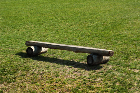 Wooden logs bench on green grass