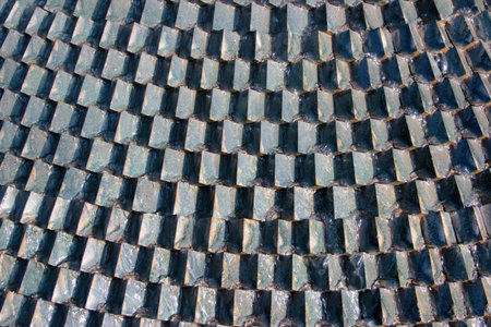 Sawtooth pattern brickwork. Decorative grey stone cubes in a wall as background
