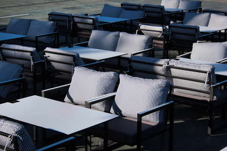Empty chairs and tables in an outdoor restaurantの写真素材