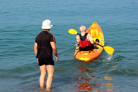 Man rowing a kayak offshore across the blue watersの写真素材