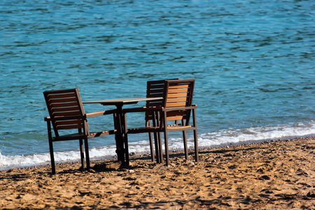 Empty table with three seats on a beachの写真素材