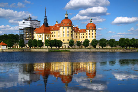 Moritzburg castle reflecting in the lake under blue skyの写真素材