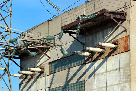 High-voltage insulators and power lines on industrial building