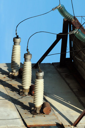 High-voltage insulators and power lines on industrial building