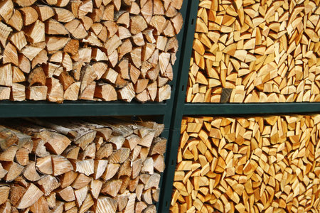 Stacked firewood in metal rack with contrasting wood tonesの写真素材