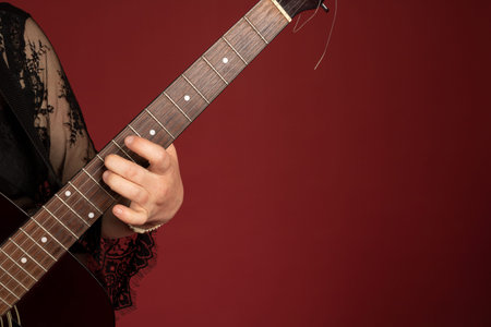 Guitarist hands on burgundy background