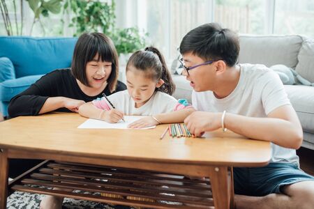 Young parents are drawing and playing with their childrenの写真素材