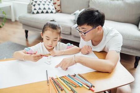 Young father is drawing and playing with the childの写真素材