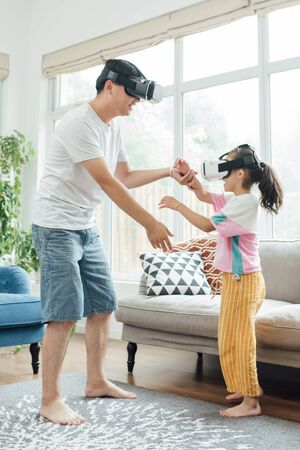 Young father and daughter are using VR virtual realityの写真素材