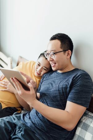 Young couple are using electronic devicesの写真素材