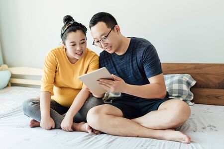 Young couple are using electronic devicesの写真素材