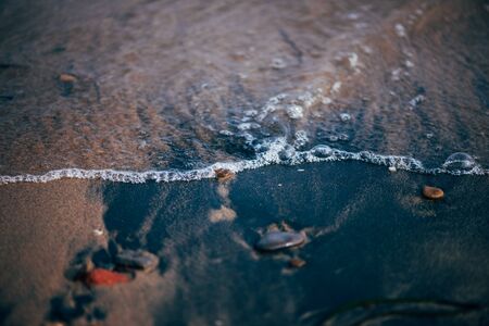 Stones and waves on the beach by the seaの写真素材