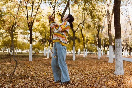 a young girl is playing in the autumn parkの写真素材
