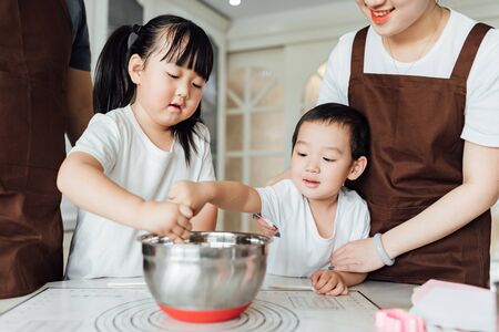 Young parents are making cakes with their childrenの写真素材