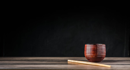 Wooden tea cup and chopsticks on the tableの写真素材