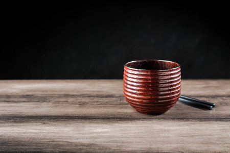 Wooden tea cup and chopsticks on the tableの写真素材