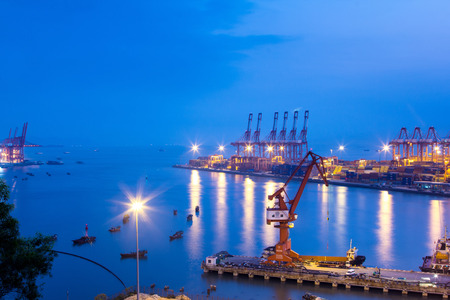 Port warehouse with cargoes and containers at nightの写真素材