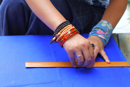 Female tailor drawing line with chalk and ruler