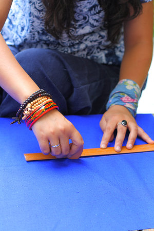 Female tailor drawing line with chalk and ruler