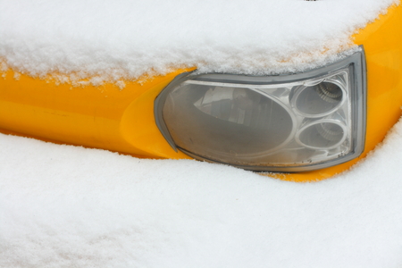 Car headlight covered with snow.の写真素材